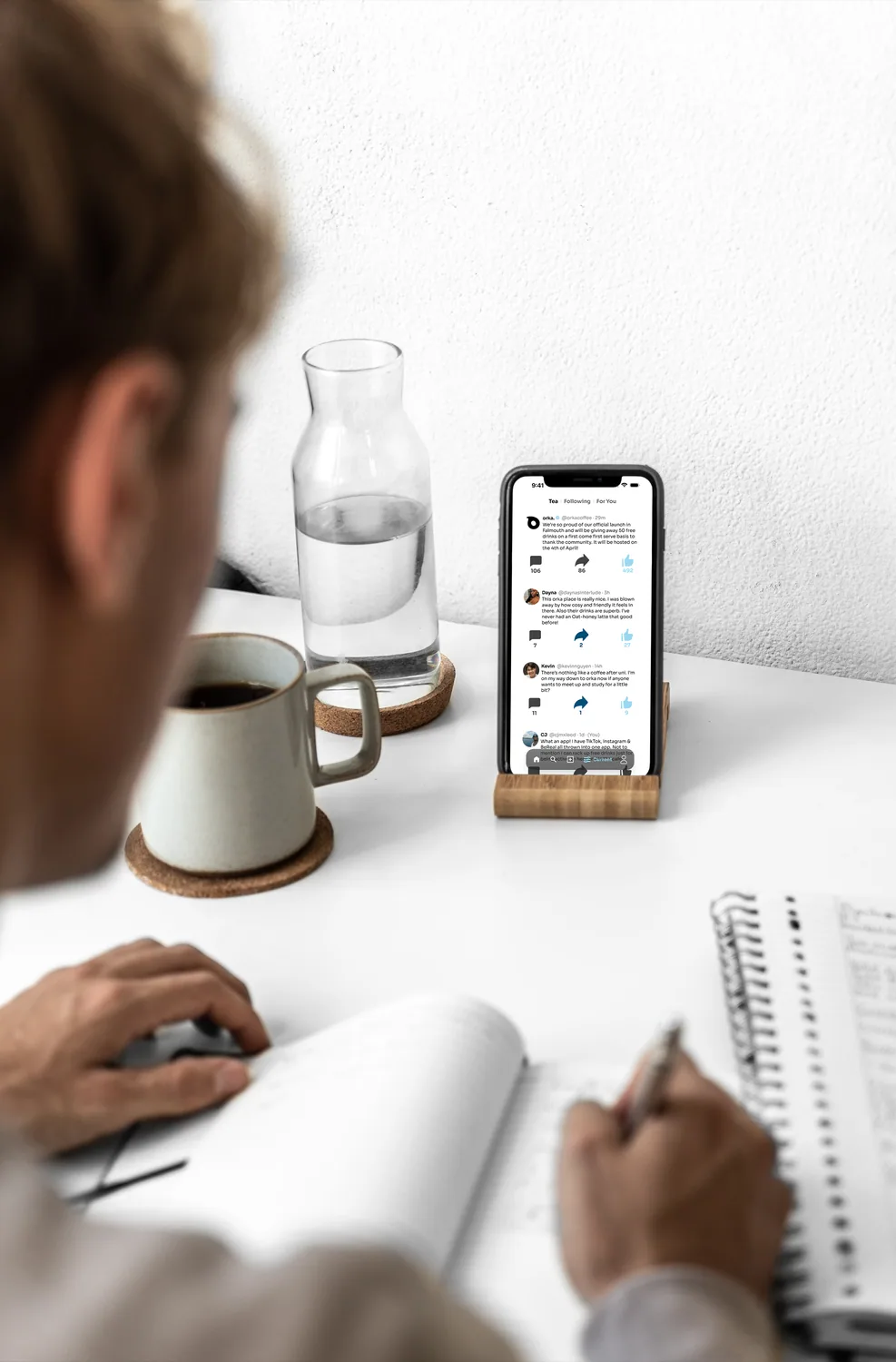 Someone using the Orka app at a desk with a coffee and a notebook